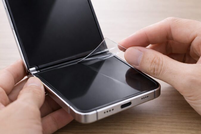 Galaxy Z Flip6の内側フィルムが浮いた状態を慎重に確認するイメージ