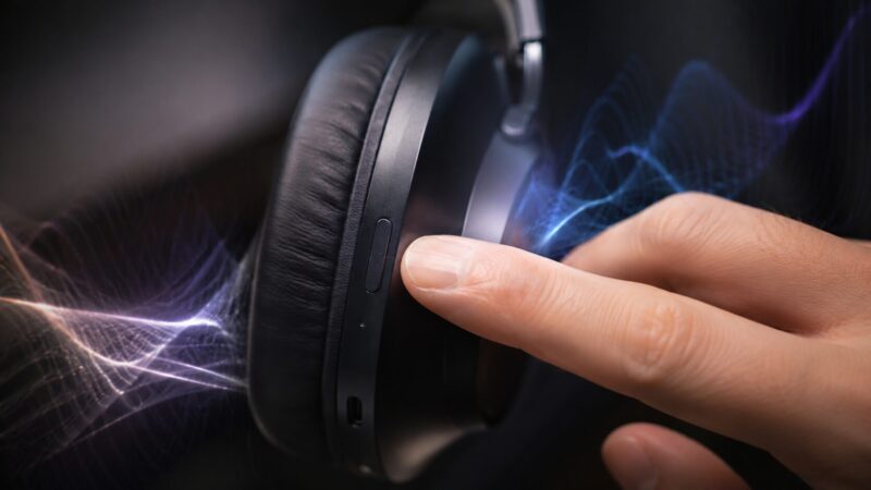 ヘッドホン側面の低音切り替えボタンを押して重低音を楽しむイメージ