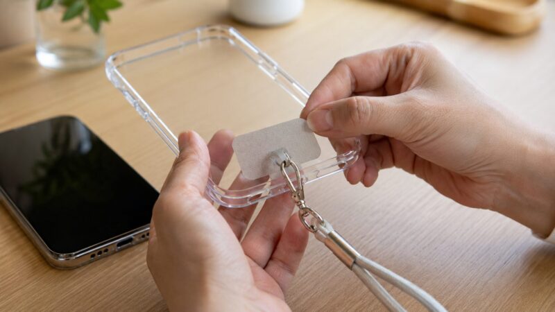 スマホケース内のストラップホルダーと金具の緩みを確認する手元