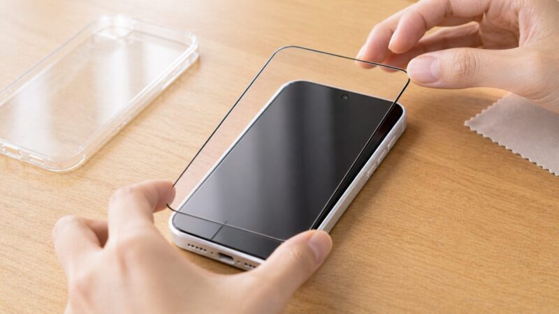 iPhone 17e用保護フィルムの位置合わせを確認する手元