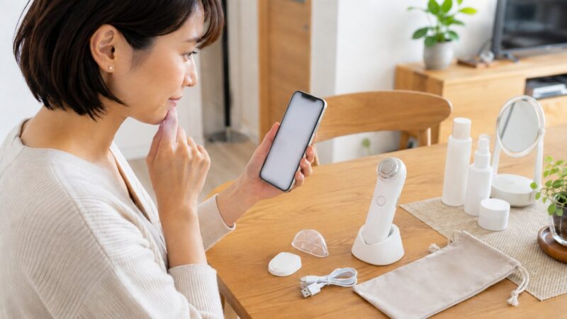 美顔器を購入する前に価格やセット内容をスマートフォンで確認する日本人女性