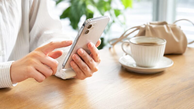 カフェでスマホに直挿しモバイルバッテリーを接続して使う様子