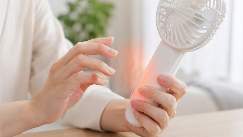異常発熱したハンディファンに触れて危険を確認する手元
