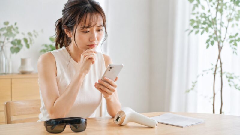 家庭用IPL脱毛器の口コミをスマホで慎重に確認する日本人女性