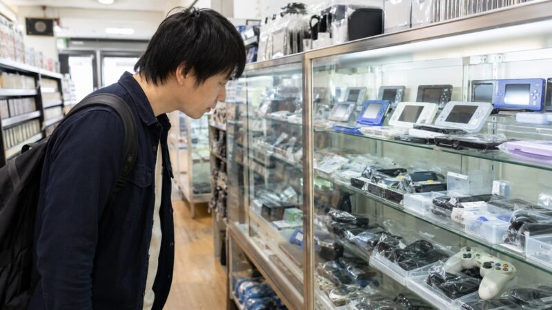 ゲオやブックオフのような中古店でPSPバッテリーを探す日本人男性