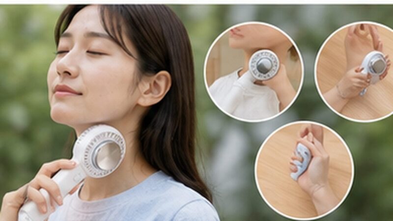 屋外でハンディファンの冷却プレートを首元へ当てる日本人女性