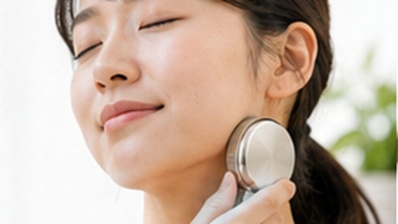 ハンディファンの冷却プレートを首元へ当てて冷たさを確かめる女性