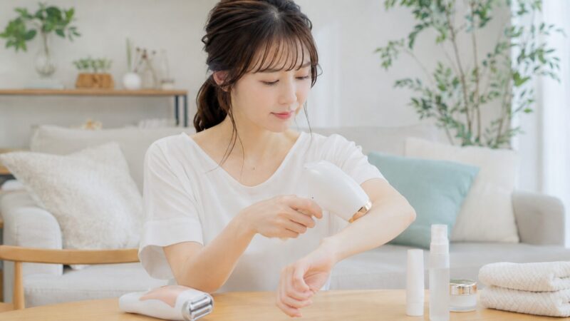 家庭用光美容器を腕に使用する日本人女性