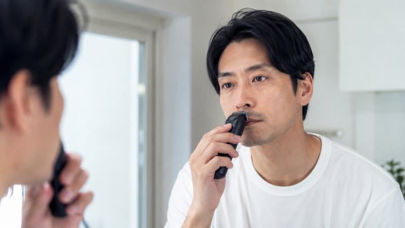 小回りの利く3枚刃シェーバーで鼻下を丁寧に剃る日本人男性