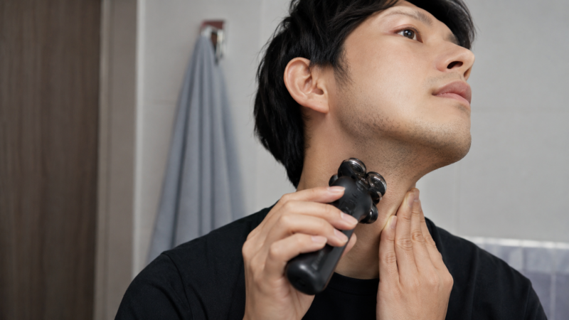回転式電動シェーバーでアゴ下と首のくせヒゲを剃る日本人男性