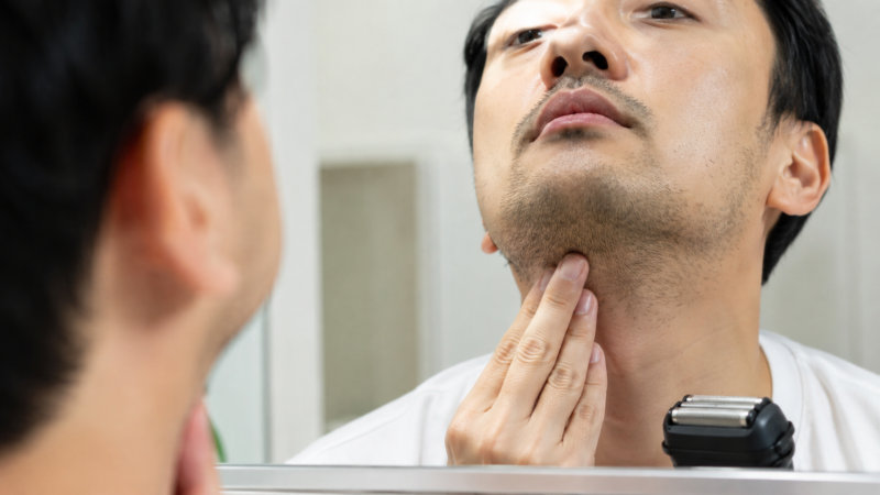 鏡でアゴ下と首のヒゲの濃さや生える向きを確認する日本人男性