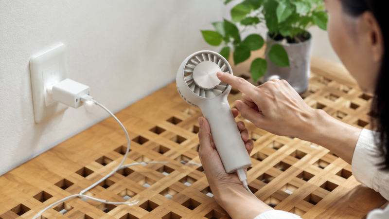 通気性のよい安定した場所でハンディファンを充電する様子
